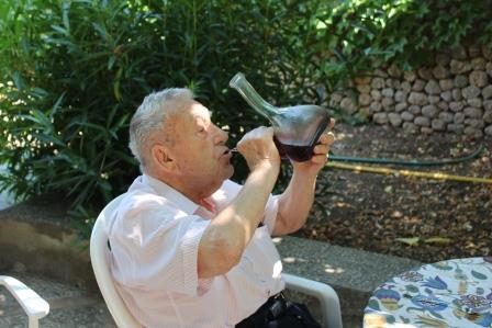 Drinking summer wine from a porron bottle.